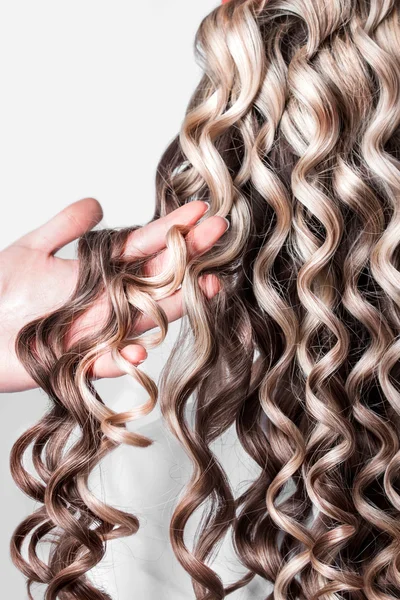 Kolunda kıvırcık sarışın saç teli