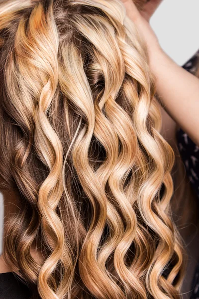 Kolunda kıvırcık sarışın saç teli