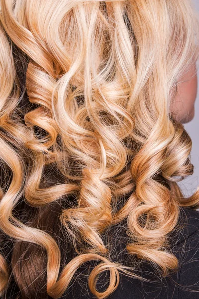 Kolunda kıvırcık sarışın saç teli