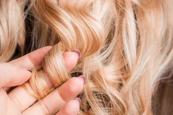 Kolunda kıvırcık sarışın saç teli