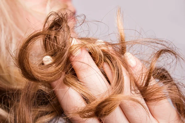 Strand kręcone blond włosy na ramieniu — Zdjęcie stockowe