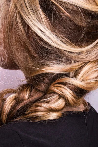 Corda de cabelo louro encaracolado em seu braço — Fotografia de Stock