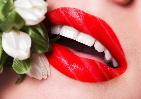 Hermosos labios sexy color saturado con un ramo de flores — Foto de Stock