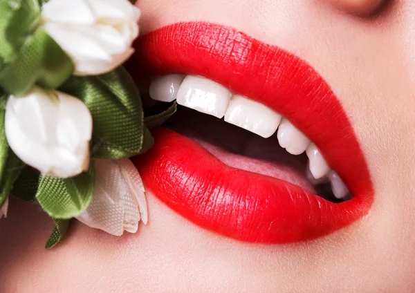 Hermosos labios sexy color saturado con un ramo de flores — Foto de Stock