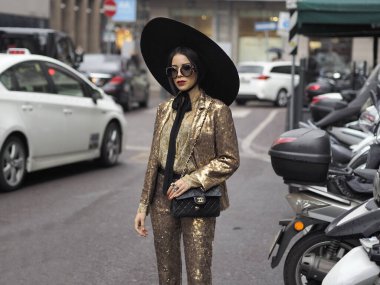 GENNY defilesinden sonra, Milan Moda Haftası Kadını döneminde İtalya 'nın Milano kentinde fotoğrafçılara poz veren şık bir kadın..