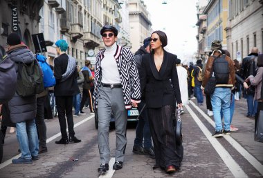Moda blogcuları Carlo Sestini ve arkadaşı, ERMANNO SCERVINO defilesinden sonra sokaklarda fotoğrafçılar için yürüyorlar. Milan Moda Haftası Kadını sonbahar / kış koleksiyonları sırasında Milan, İtalya. 