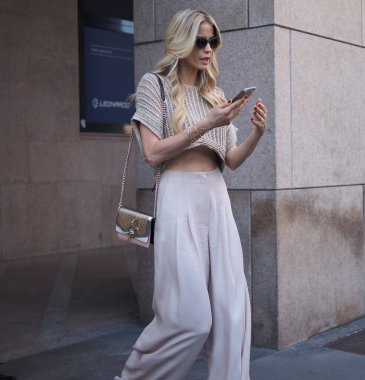 Elena Santarelli ve arkadaşı, ALBERTA FERRETTI defilesinden sonra, Milano Moda Haftası Erkek ve Kadın Baharı 'nda sokakta fotoğrafçılara poz veriyor. 