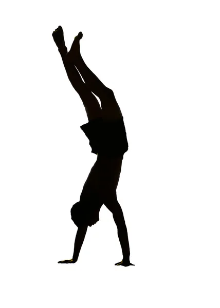 The isolate silhouette of a young man standing on hands — Stock Photo, Image