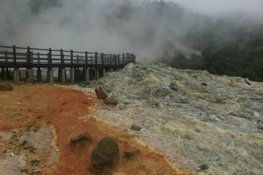 Sikidang Krateri 'ndeki dramatik köprü ve sis. Dieng Endonezya