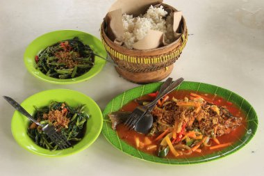 Bir servis Endonezya yemeği, sotelenmiş lahana, kızarmış tempeh, kızarmış tavuk ve taze sebze, ve tatlı ve ekşi soslu kızarmış levrek..