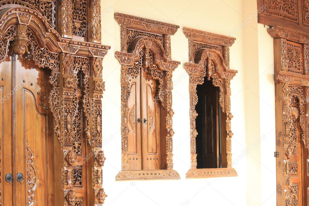 Carved and carved patterns on the walls and windows of Indonesian wooden houses, with traditional ethnic nuances that are artistic and classy.