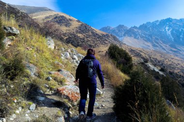 Kırgızistan, Ala Archa Ulusal Parkı 'nda yürüyüş yapan genç bir kadın..