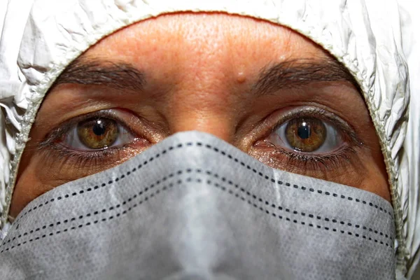 Close-up, a female health worker with overalls and protective mask to fight coronavirus. Public health concept