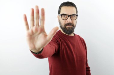 Ciddi yüzlü, sıradan kıyafetler giyen ve gözlüklü sakallı bir adam avuç içi ile dur işareti yapıyor. Olumsuz jest ile uyarı ifadesi 