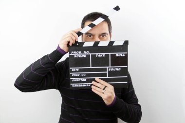 El çırpma tahtası tutan bir adam beyaz arka planda izole edilmiş bir şekilde ona bakıyor.