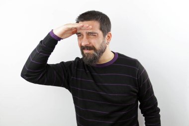 Sıradan giysiler giymiş, beyaz arka planda izole edilmiş, el üstünde alnı olan, yoğun sakallı bir adamın portresi.