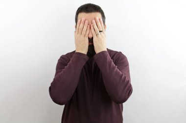 Sakallı, sıradan kıyafetler giyen, suratını elleriyle örten ve ağlayan bir adam. depresyon kavramı.