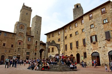 San Gimignano, Siena, İtalya - 25 Nisan 2019: Festival gününde turistler Piazza della Cisterna 'da yürür