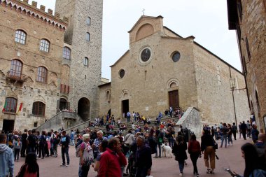 San Gimignano, Siena, İtalya - 25 Nisan 2019: Kasaba merkezindeki Piazza Duomo 'da turistler yürüyor