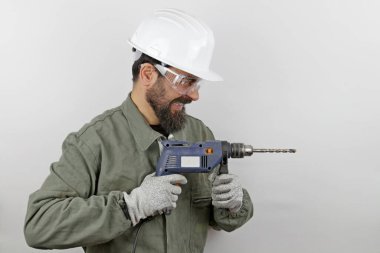 İşçi mimar kasketli bağırıyor öfke çığlıkları atıyor matkap aletleri yan yana duruyor.