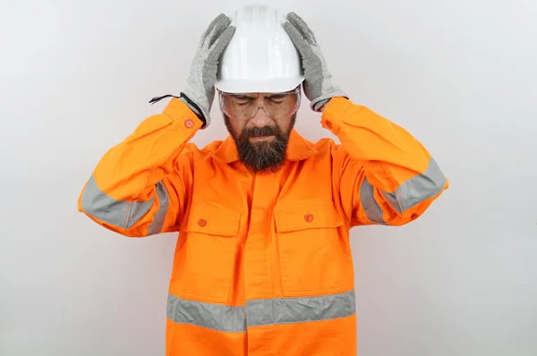 Handsome man wearing worker uniform and hardhat suffering from headache desperate and stressed because pain and migraine. hands on head.