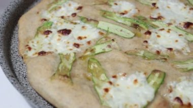 Sebze ve peynirli beyaz pizzaya yakın plan.