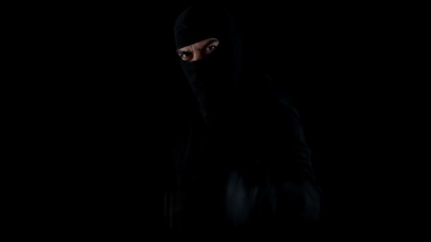 强盗穿着巴拉克拉瓦和枪在漆黑的夜晚 怒气冲冲 怒气冲冲地把手指和枪口对准摄像机 — 图库视频影像