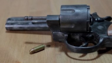 Yakın çekim magnum silahı masanın üzerinde duruyor. Dolly vurdu.