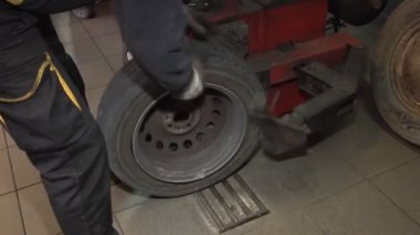 Bir araba lastiği tamircisi lastik tamir ediyor.