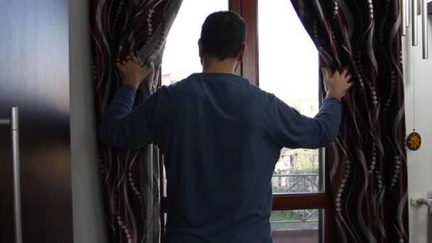 Bir Adam Sabahın Erken Saatlerinde Pencereden Dışarı Bakar Perdeyi Açar — Stok video