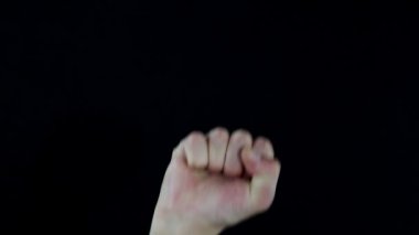 Bir adam yumruğunu havaya kaldırdı. Dayanışma, mücadele, muhalefet ve izole edilmiş siyah arkaplanda erkek eli için yükseltilmiş yumruk hareketi