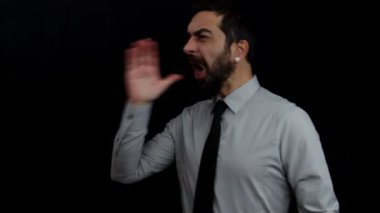 İzole edilmiş siyah arka planda kızgın yüzlü patron kolunu kaldırır ve elini ağzının kenarına koyar ve bağırır, bağırır. İş konsepti