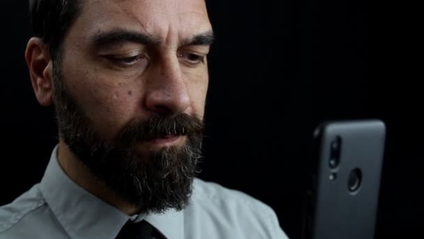 Крупним Планом Бородатий Чоловік Чорному Тлі Дивиться Типи Мобільний Тримаючи — стокове відео