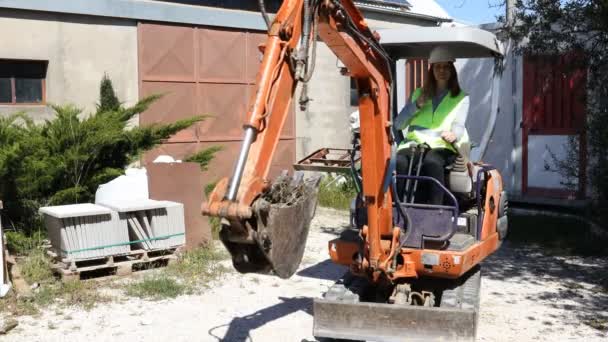 Una Trabajadora Con Sombrero Duro Conduce Una Excavadora Sitio Construcción — Vídeo de stock