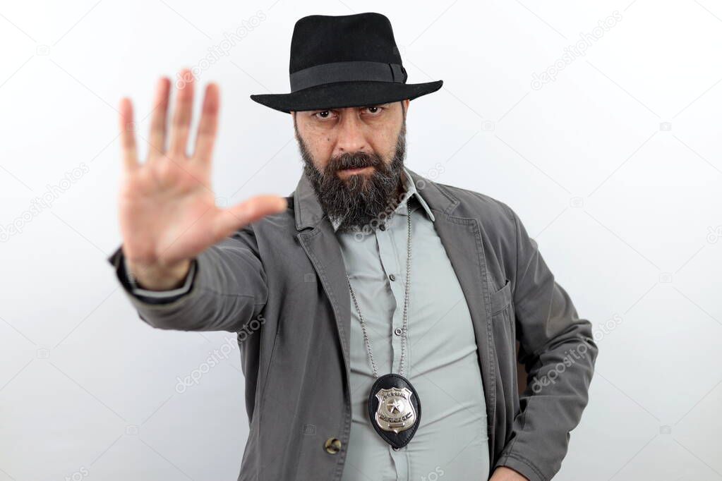 Bearded detective with serious face showing making stop sign with hand. Crime concept.