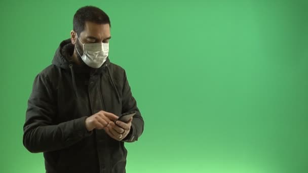 Hombre Con Tipos Máscara Protectora Teléfono Inteligente Sobre Fondo Verde — Vídeo de stock