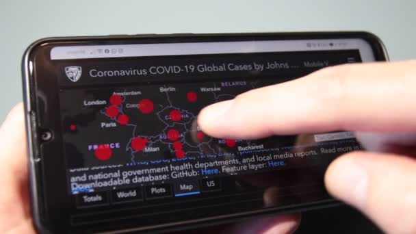 イタリア 2020年4月1日 クローズアップ Covid 19の地図上のスマートフォン画面で男の指が世界の状況を見るためにスライドします — ストック動画