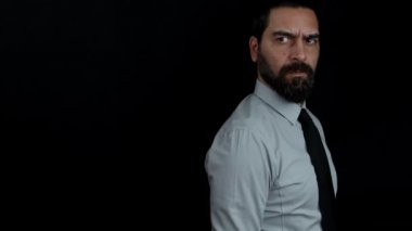 Siyah arka planda sakallı yakışıklı bir adam elinde silahla elini kaldırıyor ve nişan alıyor. Sivil giyinmiş Gangster / Polis