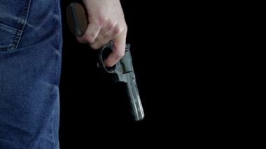 Siyah arka plandaki bir adamın elinde 380 kalibrelik Magnum tabanca var. Çekici baş parmağıyla dolduruyor.