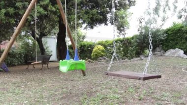 Parkta kimse olmadan salıncakta sallanıyor.