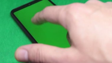Yakın plan, yeşil ekran ve yeşil arkaplan ile akıllı telefonda el yazısı.