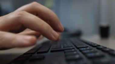 Woman works at the computer typing on the keyboard. Hand close-up.