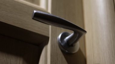 Erkeklerin eli ahşap bir kapıyı açar. Yakın plan..