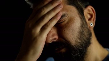 Mutsuz, yorgun bir adam, elini alnından tutuyor, sorunu, korkuları ve endişeleri düşünüyor. Baş ağrısı, hayal kırıklığına uğramış adam, uykusuzluk.