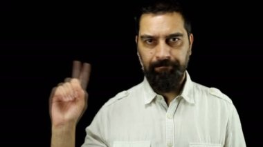 Sakallı bir adam siyah arka planda parmağını sallayarak hayır diyor..