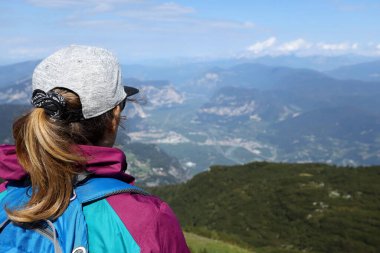 Sırt çantalı kız Trentino 'daki Paganella tepesinden Adige vadisine bakıyor..