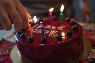 Doğum günü pastası için mum yakmak.