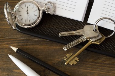 Saat ve anahtarları üstünde belgili tanımlık defter tepe görüntülemek