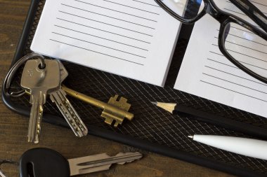 gözlük ve anahtarları üstünde belgili tanımlık defter tepe bir sürü görüntülemek