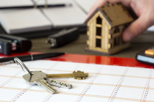 The keys of the house on a background of hands that takes a litt Stock Picture